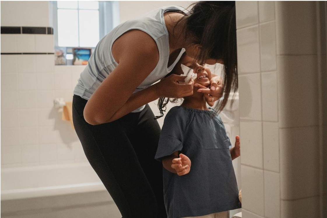 women cleaning boys face bathroom